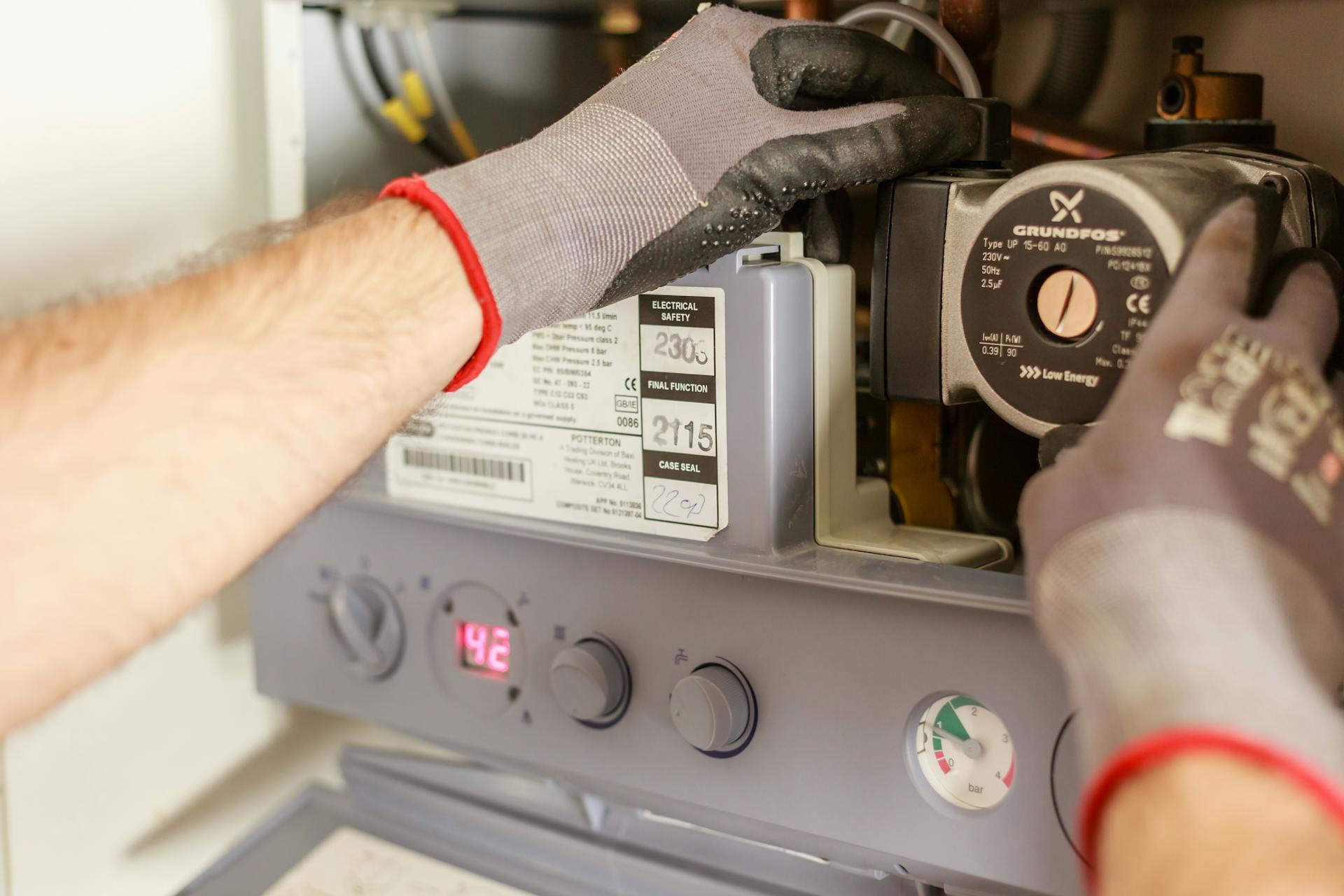 Image of an plumber carrying out boiler maintenance