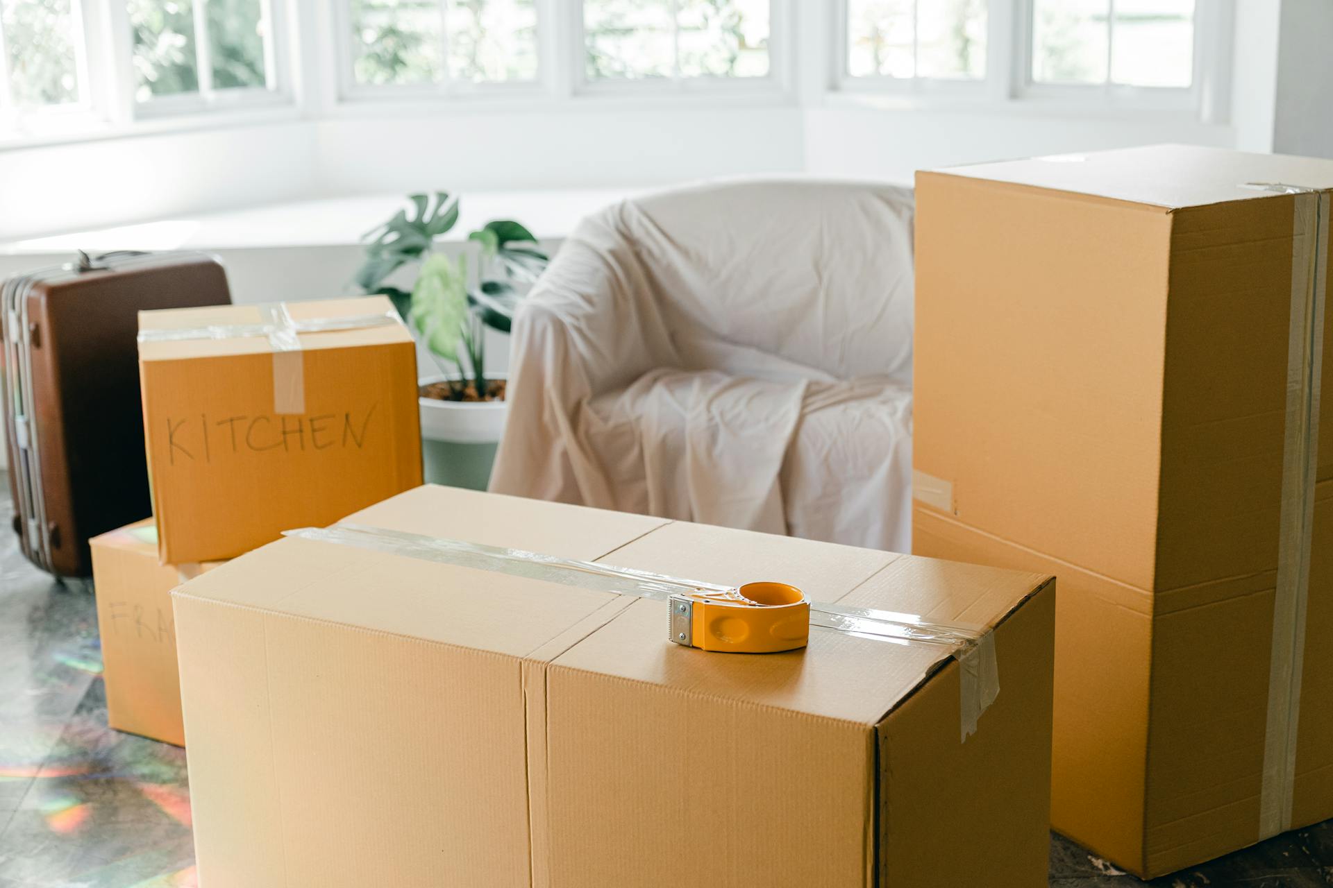 Organized moving boxes stacked neatly with labels showing room destinations